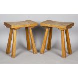 A pair of mid-20th century French Arts and Crafts style oak stools, the curved rectangular seats