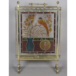 A late Victorian Aesthetic Movement brass framed and stained glass firescreen, the leaded panel