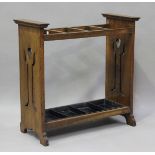 An Edwardian Arts and Crafts oak four-division stick stand, in the manner of Liberty & Co, each