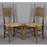 A pair of Edwardian Arts and Crafts ash framed dining chairs by William Birch, the wavy ladder backs