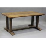 An early 20th century Arts and Crafts oak refectory dining table, raised on block supports and