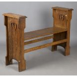 An Edwardian Arts and Crafts oak window seat, in the manner of Liberty & Co, the raised ends with