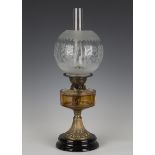 A late Victorian gilt brass and amber glass table oil lamp, height 46cm.Buyer’s Premium 29.4% (