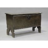 A 17th century oak six-plank coffer, the hinged lid revealing a candlebox, on shaped supports,