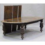 A late Victorian Carolean Revival carved oak extending dining table, the top with five extra leaves,