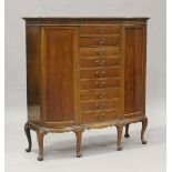 A George V mahogany bowfront side cabinet, fitted with nine central drawers flanked by cupboards, on