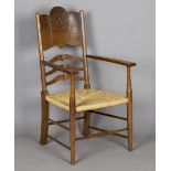 An Edwardian Arts and Crafts oak and ash framed elbow chair, in the manner of William Birch, the