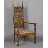 A late Victorian Anglo Moorish 'Cairene' oak framed armchair by Liberty & Co, the back inset with