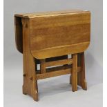 A mid-20th century Arts and Crafts style oak drop-flap table, the rectangular top above peg