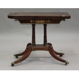 A Regency rosewood and brass inlaid fold-over card table, raised on twin columns and sabre legs,