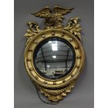 A 19th century Regency style giltwood and gesso framed circular convex wall mirror, carved with