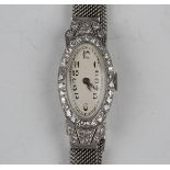 A diamond set oval cased lady's dress wristwatch with unsigned jewelled movement, the unsigned