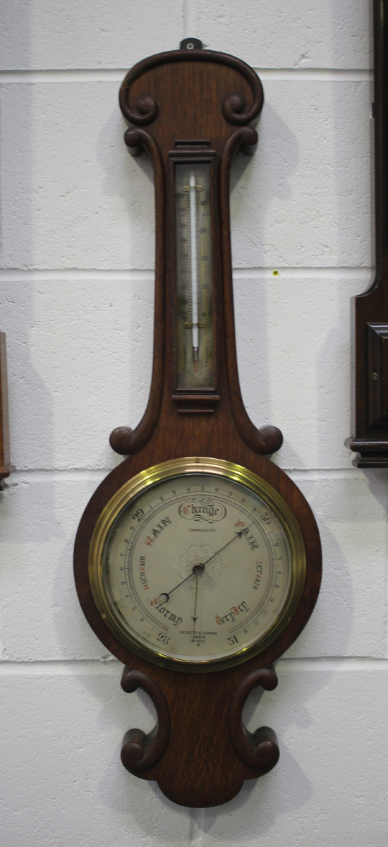 Two late Victorian wheel barometers, each with mercury thermometer, silvered dial and signed '