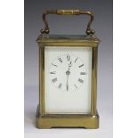 An early 20th century lacquered brass corniche cased carriage clock with eight day movement striking