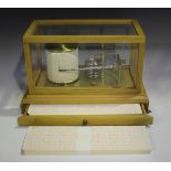 A modern pale oak cased barograph with clockwork recording drum and brass mechanism, signed '