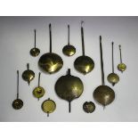 A collection of thirteen brass clock pendulums of various sizes, together with a group of eleven