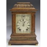 A late Victorian oak cased mantel clock with eight day movement striking on two gongs, the backplate