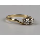 A gold and diamond two stone ring, mounted with circular cut diamonds in a crossover design,