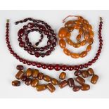 A single row necklace of fifty-nine graduated spherical cherry coloured reconstituted amber beads,