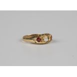 An 18ct gold ring, mounted with a garnet topped doublet and a cushion cut ruby with two pairs of