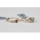 A 9ct gold ring, claw set with an oval cut red spinel between diamond set shoulders, and another 9ct