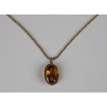 A gold pendant, collet set with an oval cut citrine within a beaded surround, weight 4g, length 2.