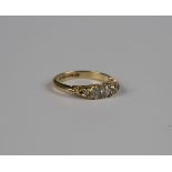 A late Victorian 18ct gold and diamond five stone ring, mounted with a row of graduated cushion
