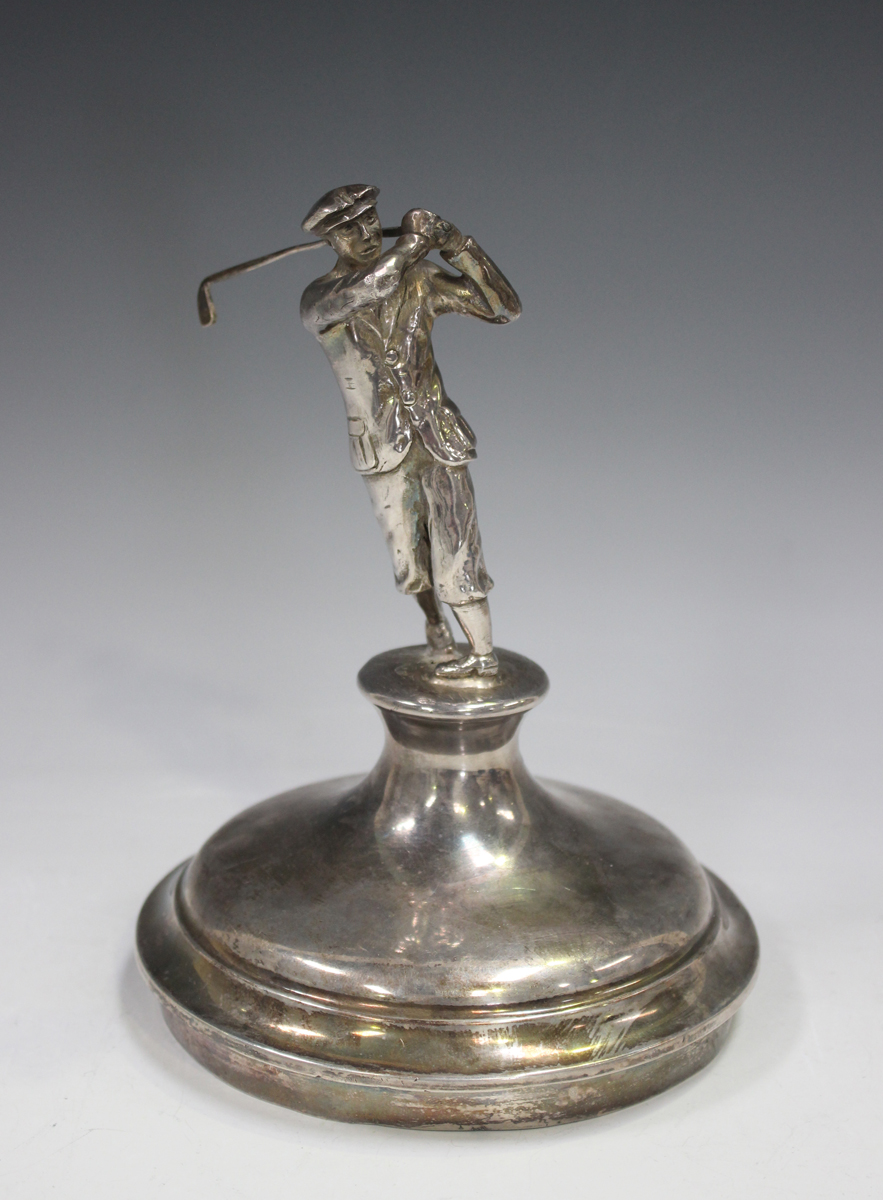 A silver trophy cup cover, the finial in the form of a golfer swinging a club, no date or maker's