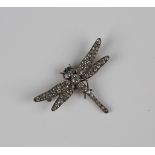 A silver and colourless paste brooch, designed as a dragonfly with green paste set eyes, detailed '