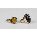 A 9ct gold ring, claw set with an oval cabochon tiger's eye between two crescent shaped smoky