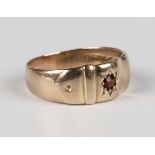 An Edwardian 9ct gold and garnet single stone ring in a strap design, star set with a cushion cut