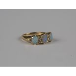 A gold, opal and diamond ring, mounted with three oval opals alternating with two pairs of cushion