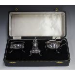 An Elizabeth II silver three-piece condiment set with gadrooned rims, on scroll legs, comprising