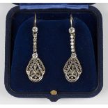 A pair of diamond pendant earrings, each drop of pierced foliate openwork design above a diamond