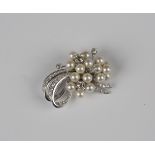 A diamond and cultured pearl brooch in a swirl and spray design, mounted with cushion cut