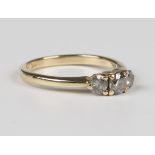 A gold and diamond three stone ring, claw set with a row of circular cut diamonds, detailed '14K',