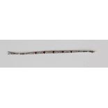 A ruby and diamond bracelet, designed as a row of five graduated collet set oval cut rubies