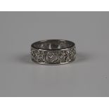 A diamond eternity ring, pierced in a foliate and scrolling design, mounted with circular cut