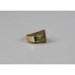 A gold ring of abstract design, mounted with a cut cornered rectangular step cut peridot, weight 7.