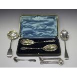 A near pair of Edwardian silver berry spoons, each ovoid bowl decorated in relief with flowers,