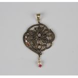 An Indian silver gilt, diamond, red gem and imitation pearl pendant in a floral and scroll pierced