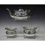 A George V silver three-piece tea set, each of cushion form with outswept pierced foliate rims,