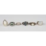 A silver ring, claw set with an oval opal between pierced shoulders, detailed '925', a silver and