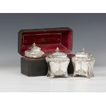 A set of three George III silver graduated tea caddies and covers with strawberry finials, each of