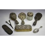 An Edwardian silver mounted six-piece dressing table set, embossed with mask and foliate scrolls,