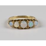 A late Victorian 18ct gold and opal five stone ring, mounted with a row of graduated opals,