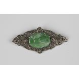 A silver, jade and marcasite brooch, circa 1930, of shaped oval form, pierced with floral