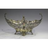 A George V silver boat shaped basket with pierced garland and scroll sides beneath a cast shaped