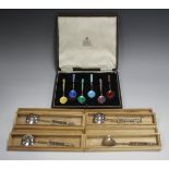 A set of six Elizabeth II silver and enamelled coffee spoons, each front enamelled in a different