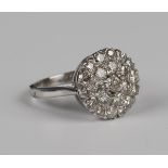 An 18ct white gold and diamond cluster ring, the principal circular cut diamond mounted to the